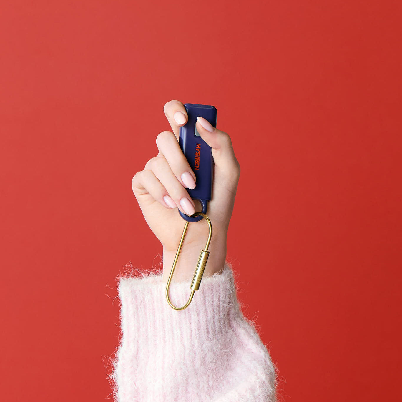 "Woman using MySiren OG safety device for personal protection while walking"